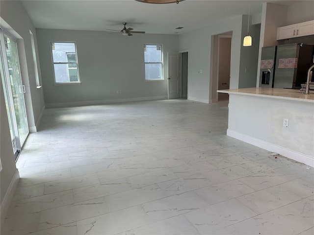 unfurnished room with sink, ceiling fan, and light tile floors