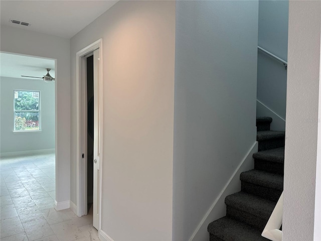 stairs with ceiling fan and light tile flooring