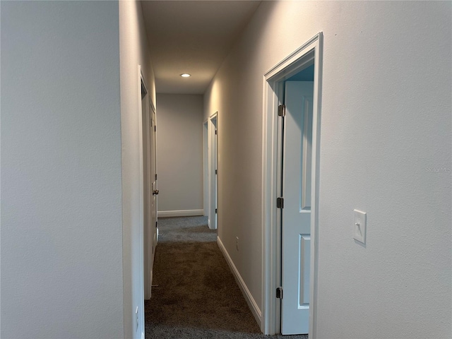 hallway with dark colored carpet