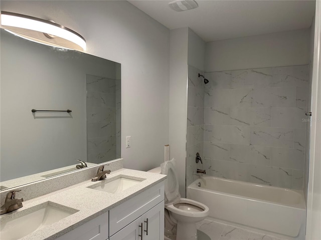 full bathroom featuring tile flooring, double sink vanity, tiled shower / bath, and toilet