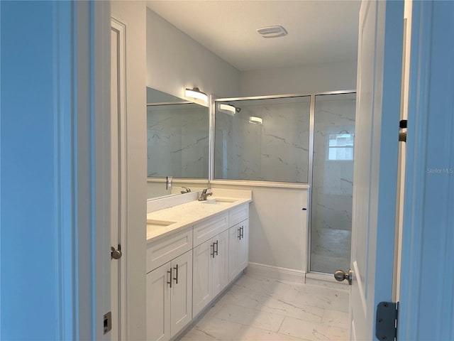 bathroom featuring a shower with shower door, double vanity, and tile floors