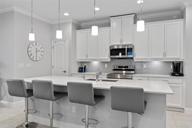 kitchen with appliances with stainless steel finishes, white cabinetry, pendant lighting, and light tile floors