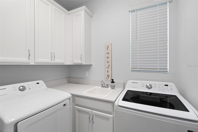 clothes washing area with sink, cabinets, and washing machine and clothes dryer