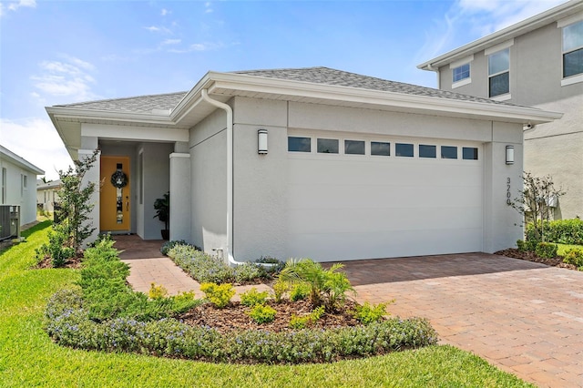 view of front of home featuring a garage and central AC unit