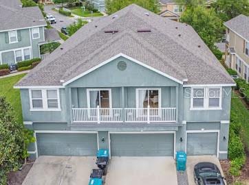 view of front of house featuring a garage, a balcony, and central air condition unit