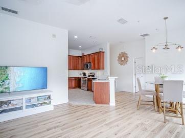 kitchen featuring stove, decorative light fixtures, and light wood-type flooring