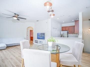 dining area with light hardwood / wood-style floors and ceiling fan