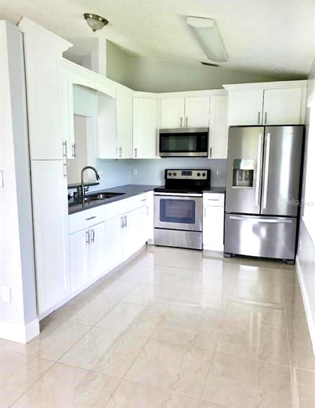 kitchen featuring sink, light tile floors, white cabinets, and appliances with stainless steel finishes