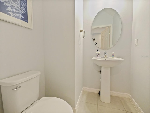 bathroom featuring tile flooring and toilet