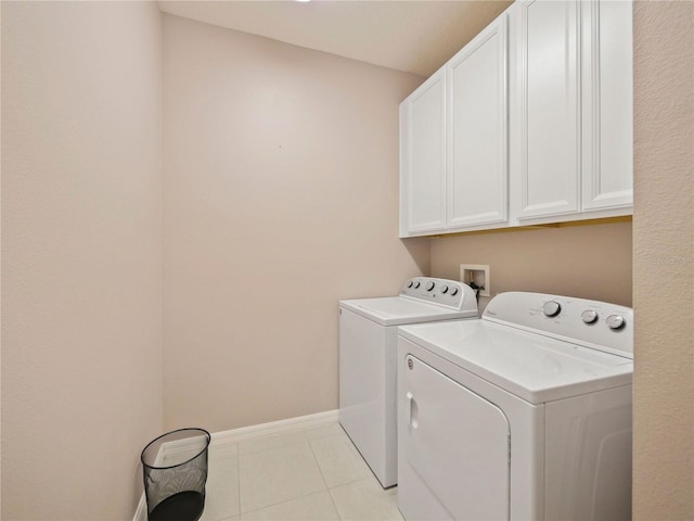 laundry room with cabinets, hookup for a washing machine, light tile floors, and washing machine and clothes dryer