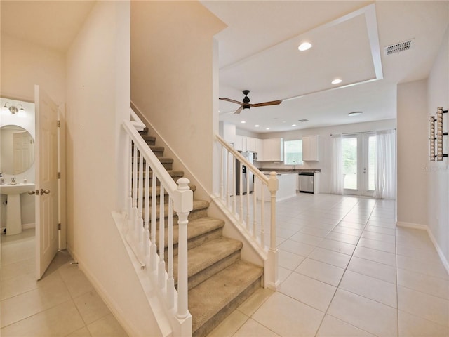 stairs with ceiling fan, french doors, sink, and light tile floors