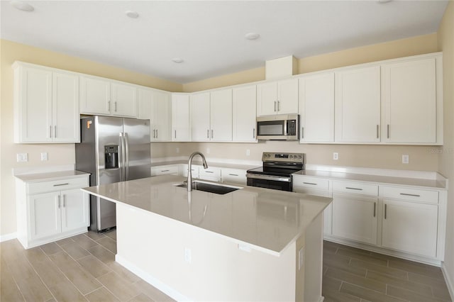 kitchen featuring sink, white cabinetry, stainless steel appliances, and a kitchen island with sink