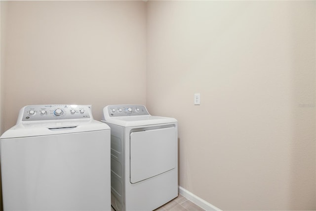 laundry area featuring washer and dryer and light tile patterned floors