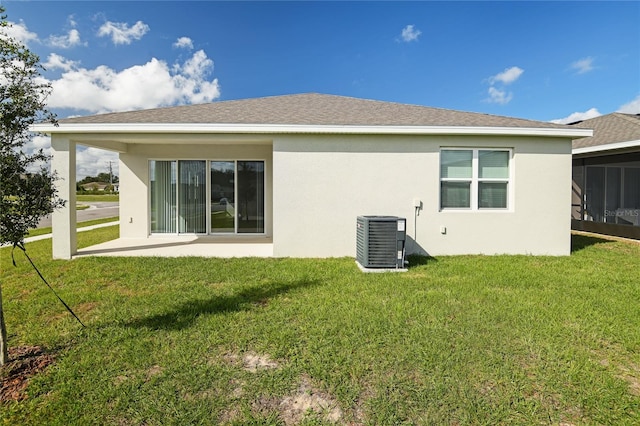 back of house with central AC unit, a patio area, and a lawn