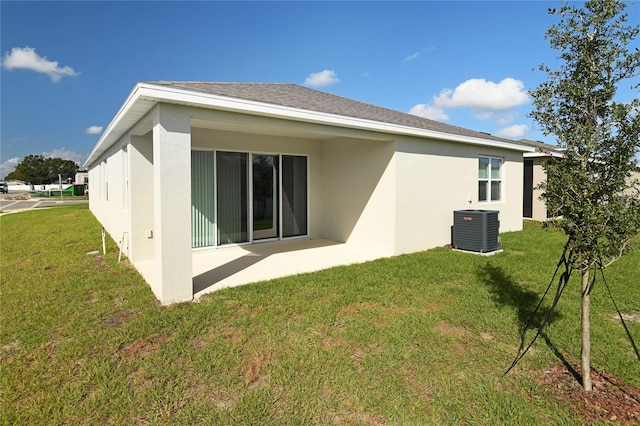 rear view of house with a lawn and cooling unit