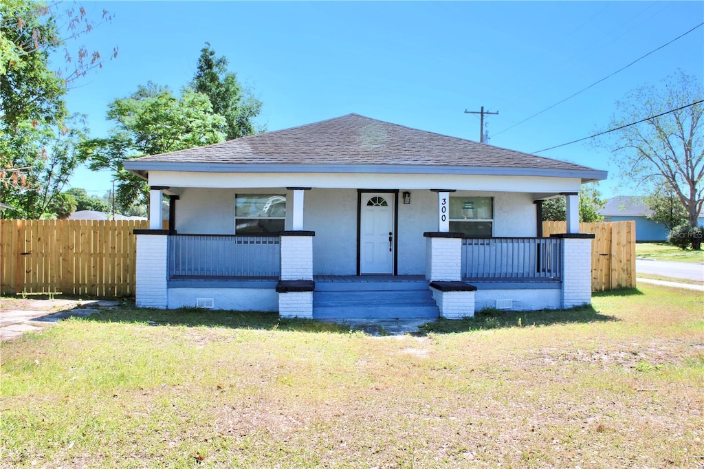 bungalow with a front yard and a porch