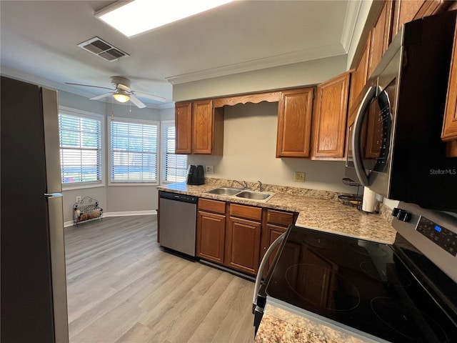 kitchen featuring stainless steel appliances, light hardwood / wood-style flooring, sink, crown molding, and ceiling fan