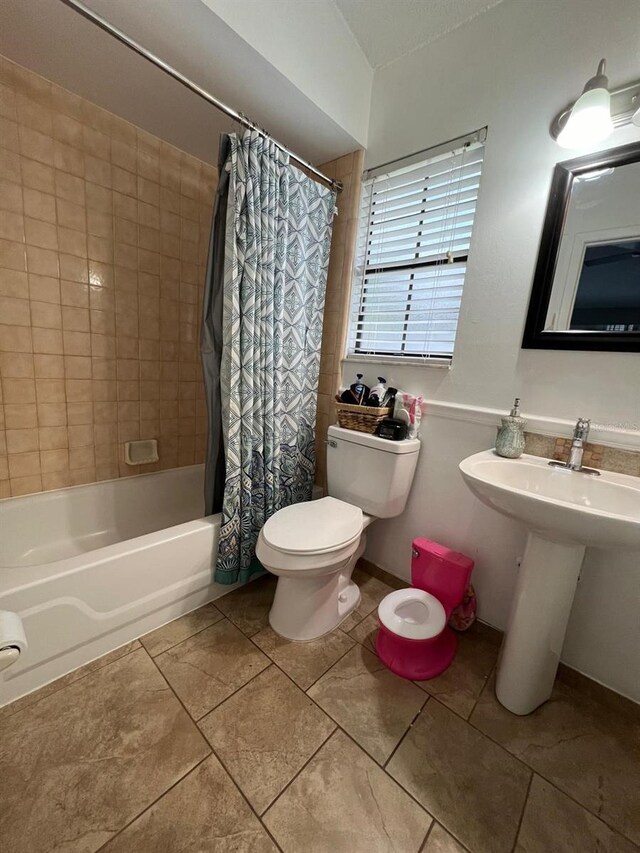 bathroom featuring tile patterned floors, shower / bath combination with curtain, and toilet