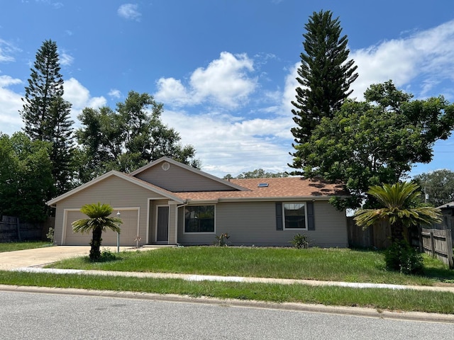 single story home featuring an attached garage, fence, a front lawn, and concrete driveway