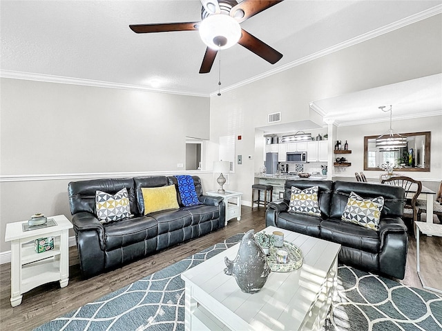 living room featuring hardwood / wood-style floors, ceiling fan, and crown molding