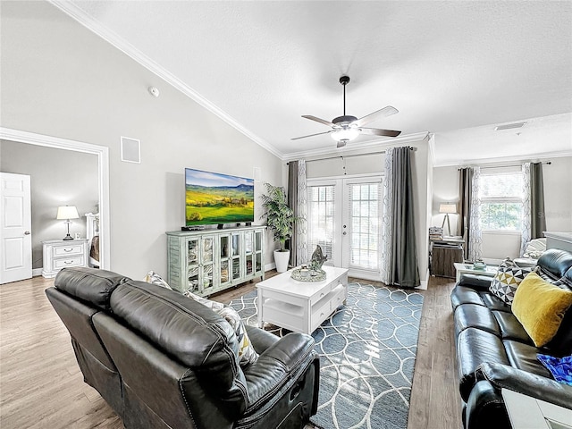 living room featuring ceiling fan, vaulted ceiling, hardwood / wood-style floors, a wealth of natural light, and ornamental molding