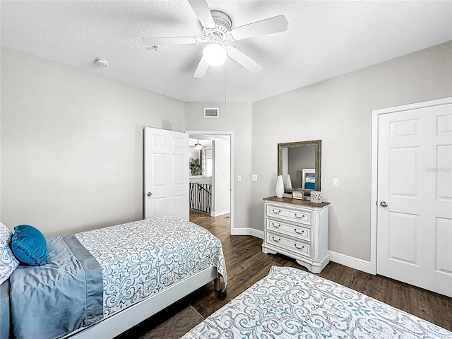 bedroom featuring ceiling fan, dark hardwood / wood-style floors, and a textured ceiling