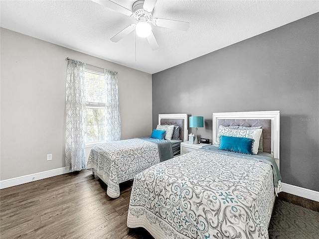 bedroom featuring dark hardwood / wood-style flooring, ceiling fan, and a textured ceiling