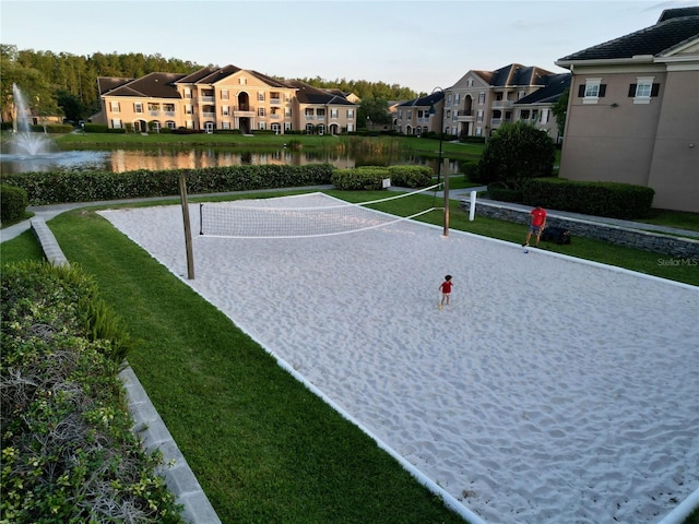 surrounding community featuring a water view and a lawn