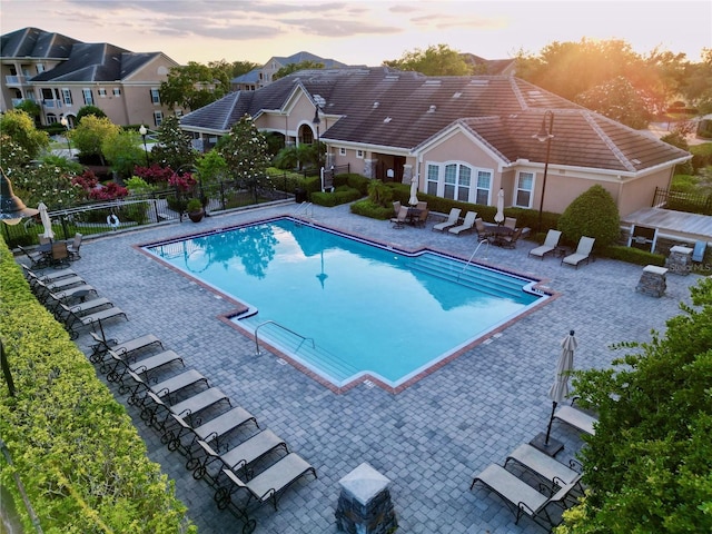 pool at dusk featuring a patio area