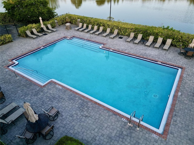 view of pool featuring a patio area and a water view