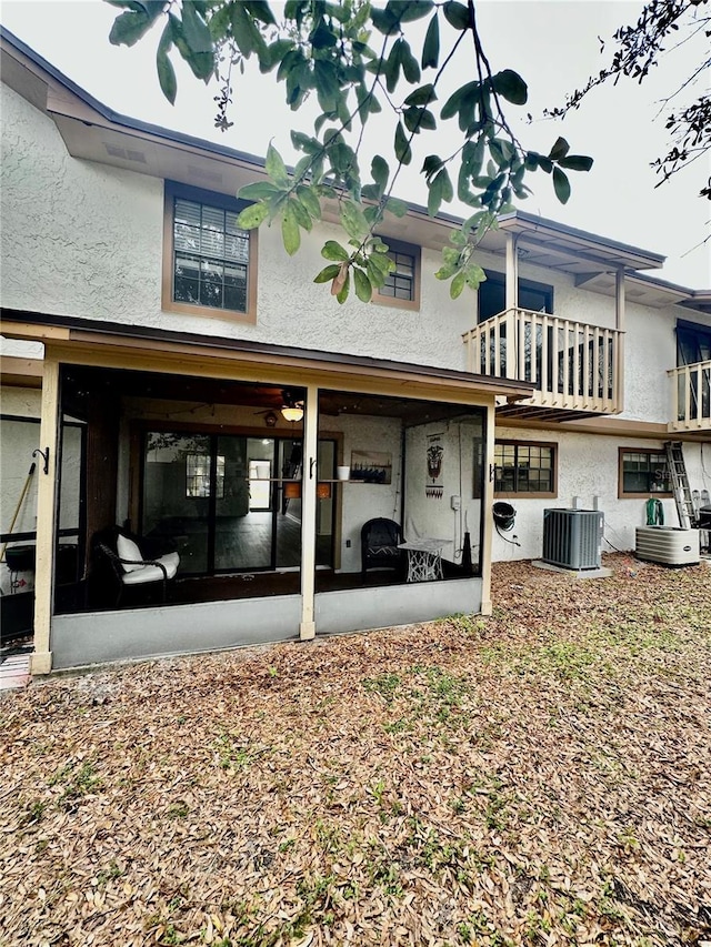 rear view of property featuring a sunroom and central air condition unit