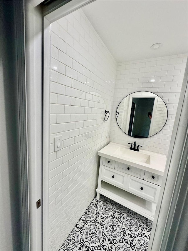 bathroom featuring tile patterned flooring, vanity, and tile walls