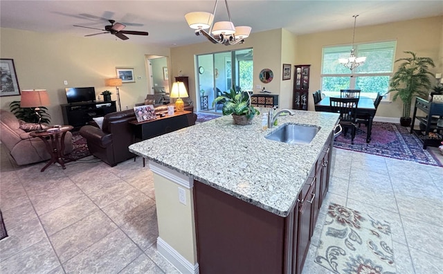 kitchen featuring ceiling fan with notable chandelier, sink, pendant lighting, and light tile floors