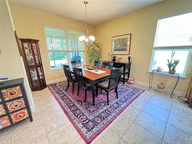 tiled dining room featuring an inviting chandelier