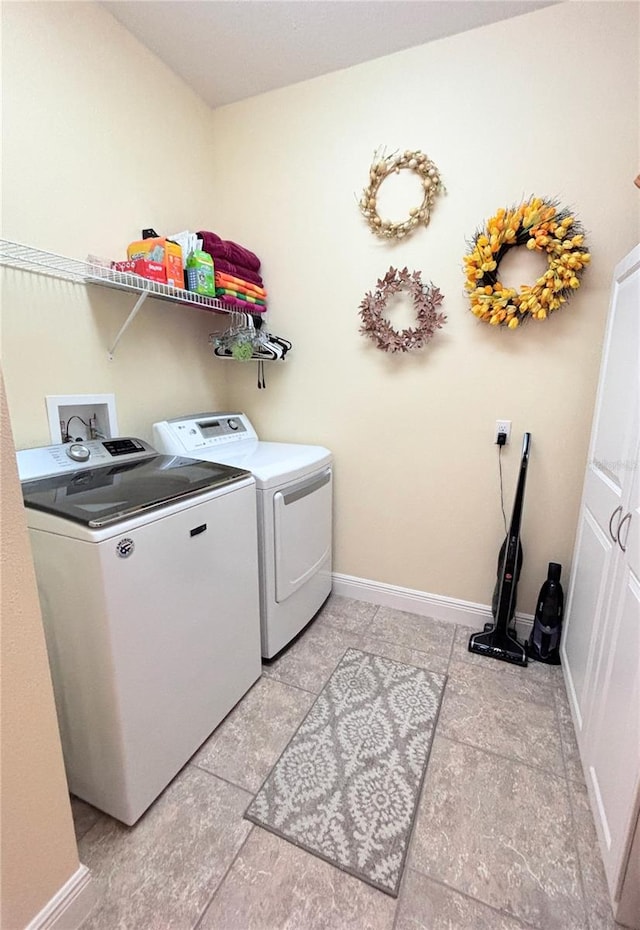 laundry area with independent washer and dryer and light tile floors