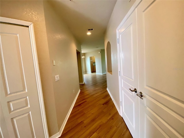 corridor with hardwood / wood-style flooring