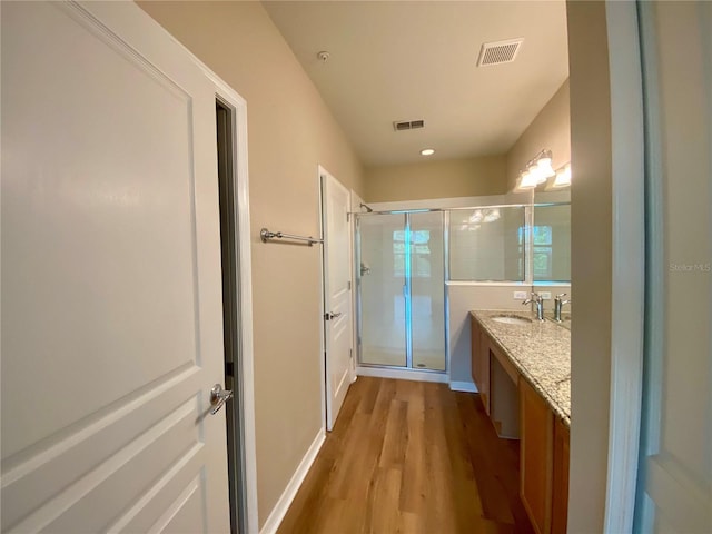 bathroom with hardwood / wood-style floors, oversized vanity, and an enclosed shower