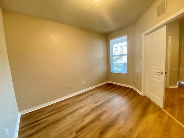 unfurnished room with wood-type flooring