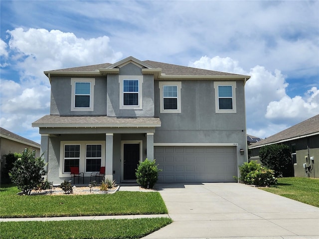 view of front property featuring a garage and a front lawn