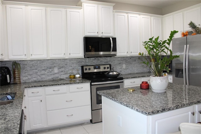 kitchen with a center island, tasteful backsplash, stainless steel appliances, and white cabinets