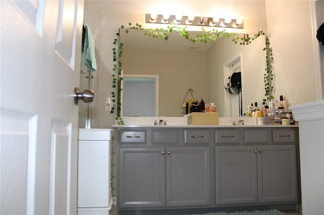 bathroom featuring vanity with extensive cabinet space and dual sinks