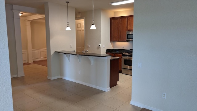 kitchen with light tile flooring, a kitchen breakfast bar, stainless steel appliances, kitchen peninsula, and pendant lighting