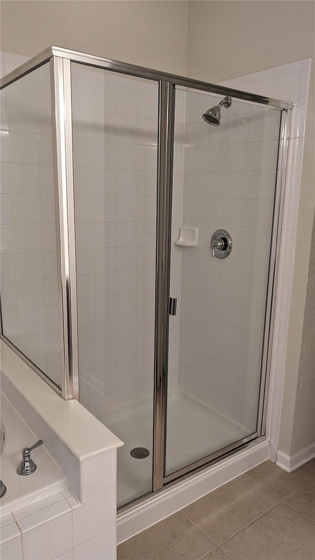 bathroom featuring an enclosed shower and tile floors