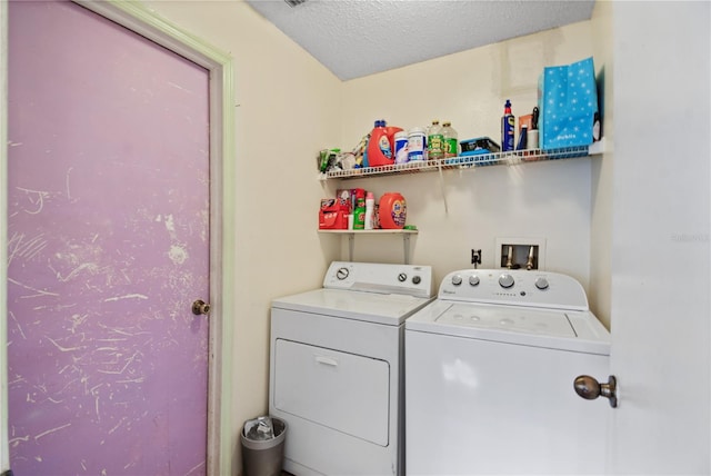 laundry area featuring washing machine and clothes dryer and a textured ceiling