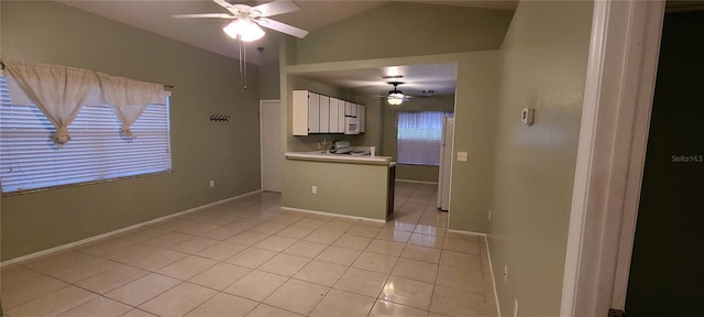 interior space with lofted ceiling, ceiling fan, and light tile patterned floors