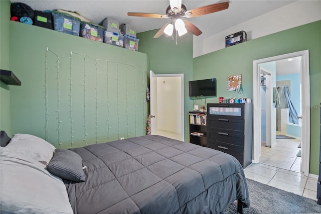 tiled bedroom with ceiling fan and ensuite bath