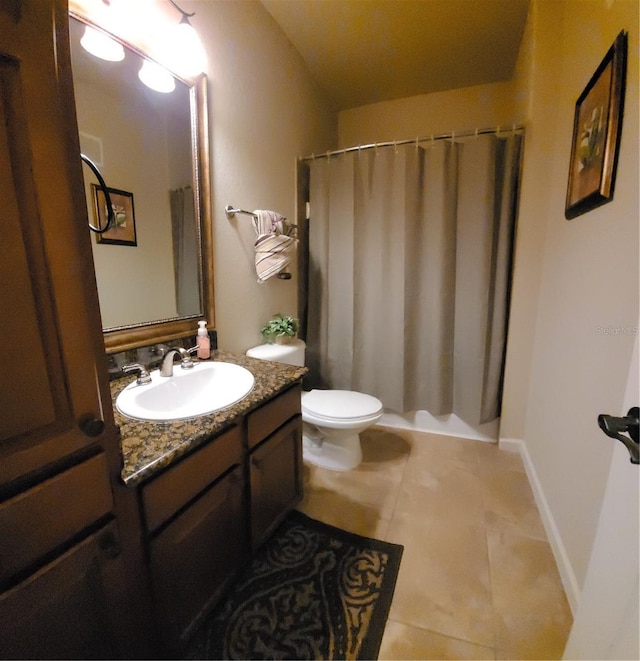 bathroom featuring tile flooring, vanity, and toilet