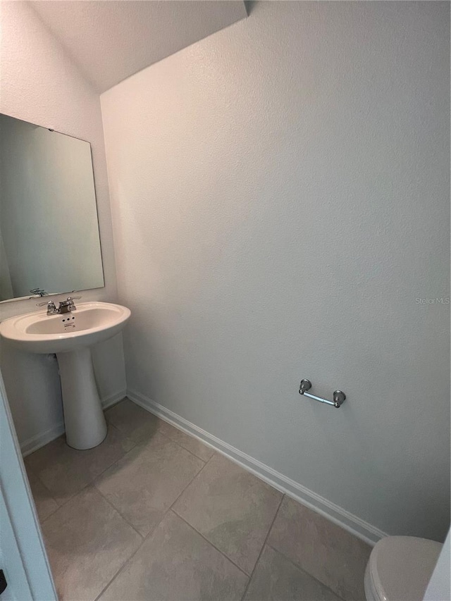 bathroom featuring tile floors and toilet