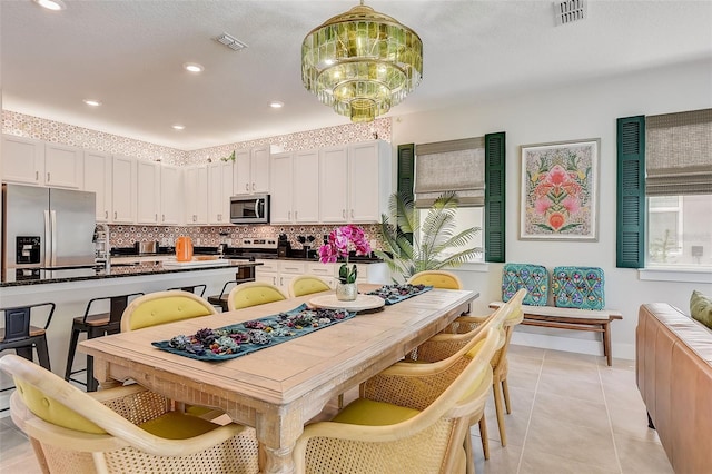 kitchen featuring pendant lighting, stainless steel appliances, white cabinetry, and a healthy amount of sunlight