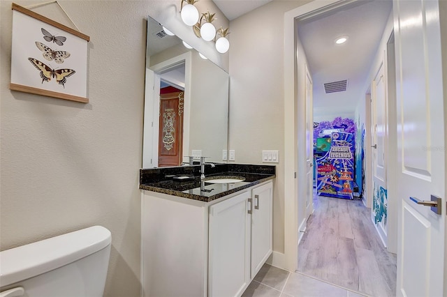 bathroom with tile patterned flooring, vanity, and toilet